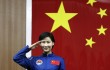 China's first female astronaut Liu Yang salutes during a news conference at Jiuquan Satellite Launch Center